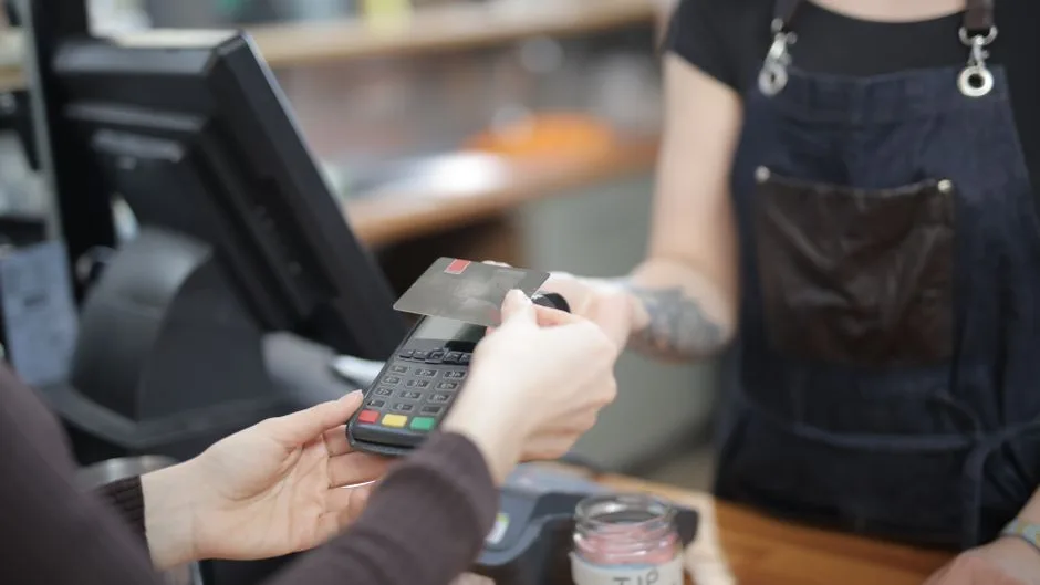 Cliente réglant ses achats par carte au comptoir d’un commerce